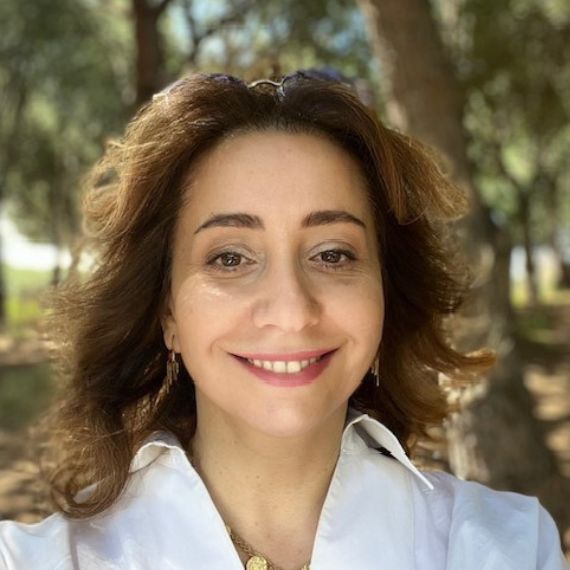 Lady with brown hair wearing white collared shirt